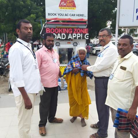 Foundation staff and community members supporting an elder woman.