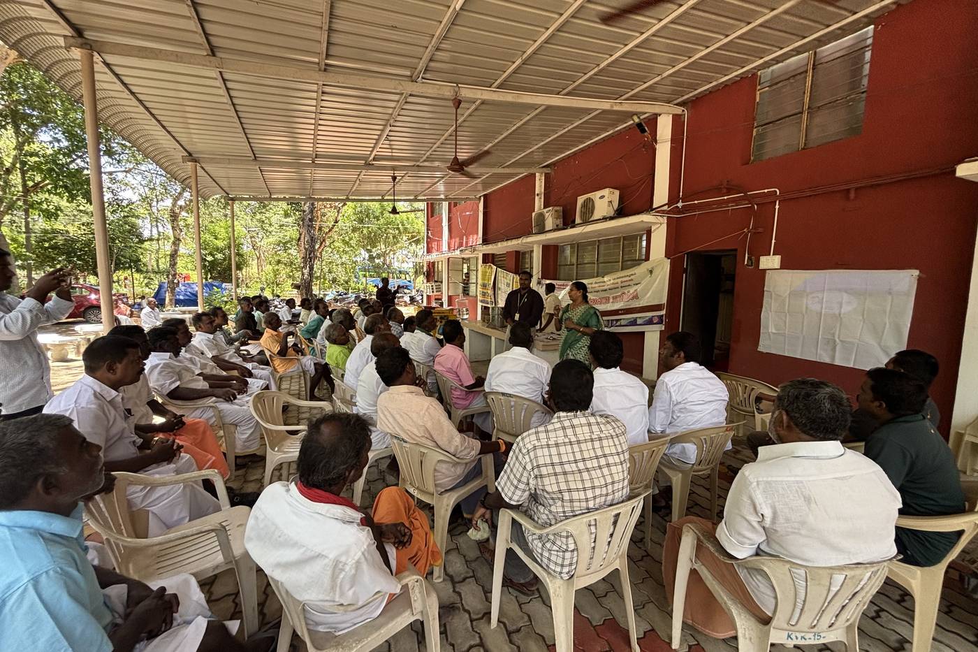 Farmers seated under a shed at a training session.