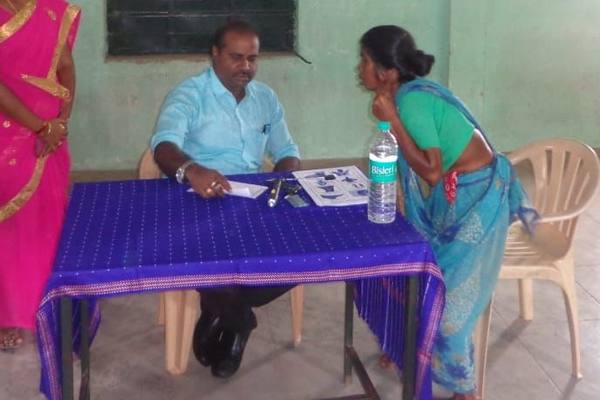 A medical awareness camp, staff seated at a desk answering questions.