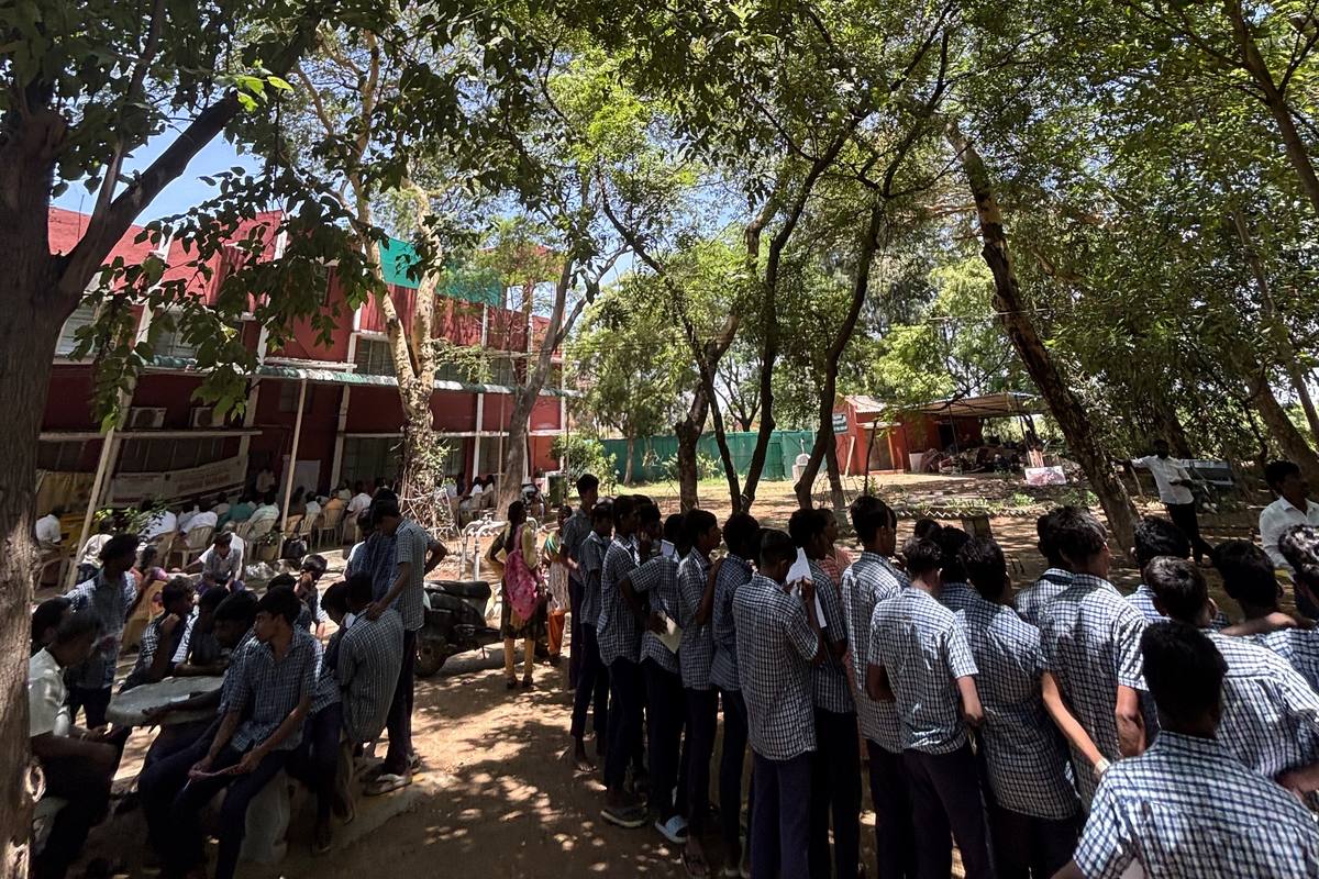 A youth programme held under the trees on campus.